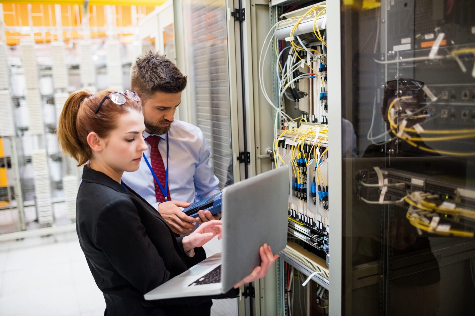 Technicians using laptop while analyzing server